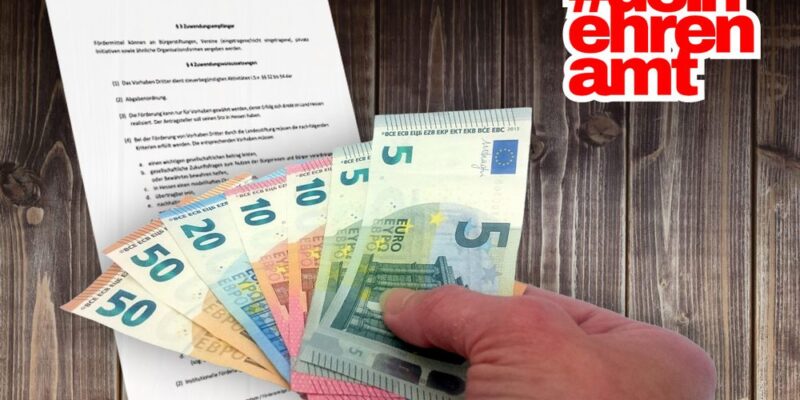 Geld und ein Förderantrag auf einer Bretterwand